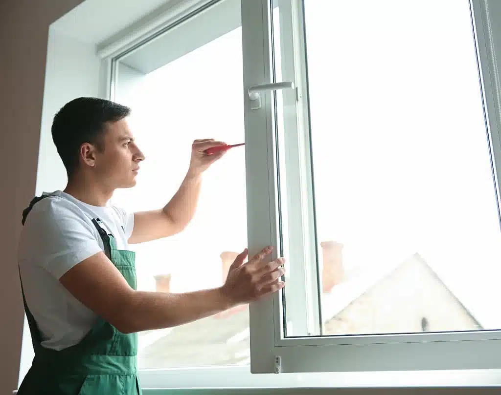 A man in an apron is pointing to the window.