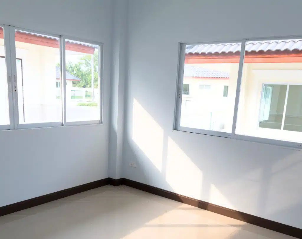 A room with two windows and a white floor.
