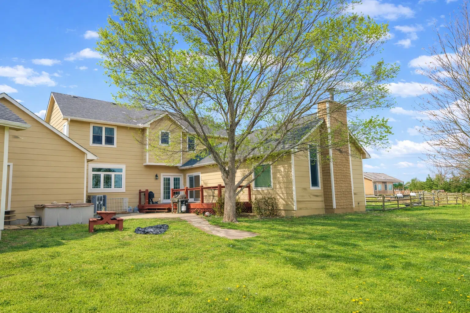Backyard view of siding installation on home with deck in Andover, KS by Greenway Exteriors